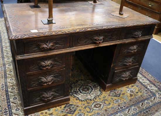 A late Victorian carved oak pedestal desk, W.4ft